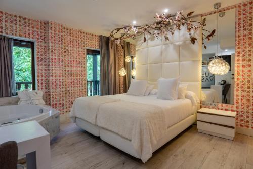 a bedroom with a large bed and a bath tub at Hotel Cuevas - Adults Only in Santillana del Mar