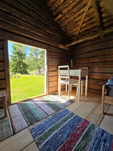 a room with a table and a window in a log cabin at Stockboden Kvarken Off Grid Cabin No Electricity or Running Water in Oravais