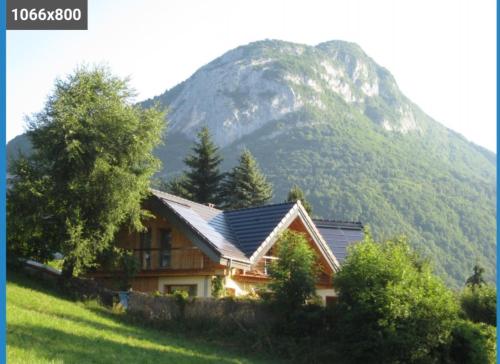 a house on a hill with a mountain in the background at pas dispo moins de 5 nuits Ecogite du lac in La Thuile