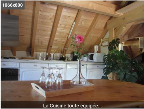 a kitchen with a table with a vase with a flower in it at pas dispo moins de 5 nuits Ecogite du lac in La Thuile