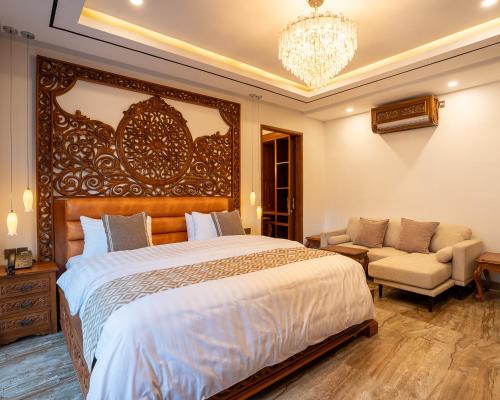 a bedroom with a large bed and a chandelier at MJ Villa Sanur in Sanur