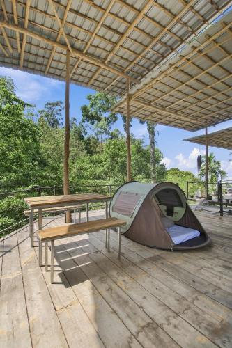 a tent and a picnic table and a bench on a deck at Jungle Nest Ella in Ella