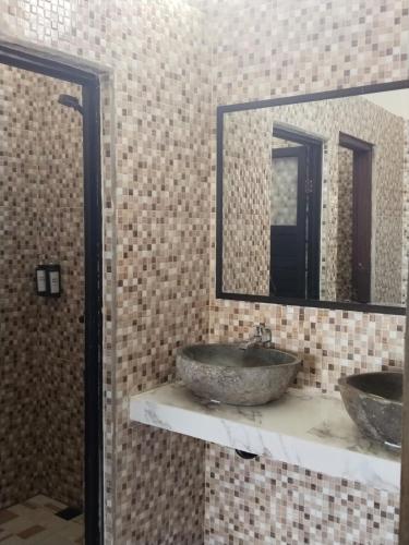 a bathroom with two sinks and two mirrors at Relaxing Homestay & Hostel in Kuta Lombok