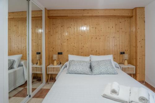 Ein Schlafzimmer mit einem großen weißen Bett und Holzwänden in der Unterkunft Calma Cazorla in Cazorla