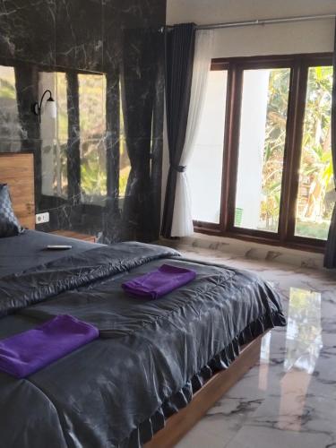 a bed with two purple pillows on top of it at Relaxing Homestay & Hostel in Kuta Lombok