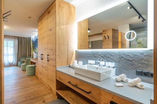 a bathroom with a sink and a mirror at Hotel Mittagskogel Pitztal in Sankt Leonhard im Pitztal
