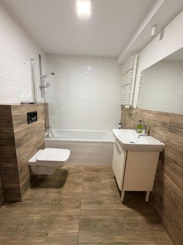 a bathroom with a sink and a toilet and a tub at Apartament COMFORT Centrum 2 in Krotoszyn