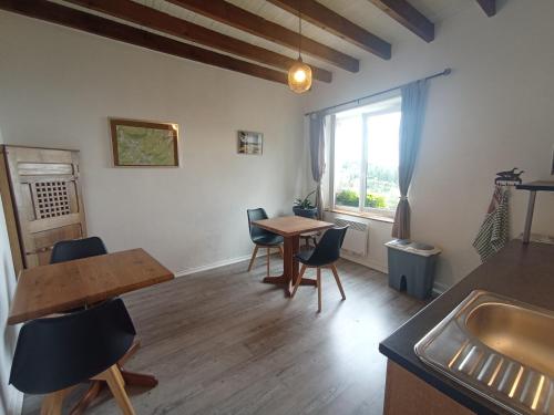 a living room with a table and chairs and a sink at B&B Les Paddocks in Vollore-Montagne