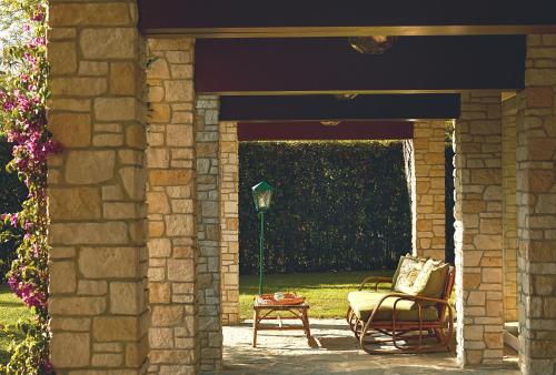 a stone archway with a chair and a table at Hermitage Hotel & Resort Forte dei Marmi - Starhotels Collezione in Forte dei Marmi