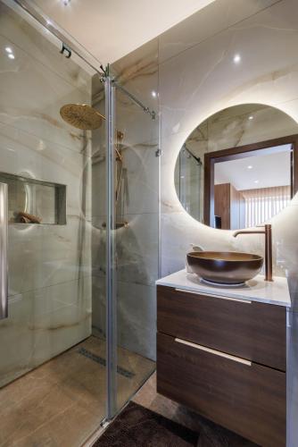 a bathroom with a sink and a glass shower at Bayleaf Coastal Apartment in Marsaxlokk