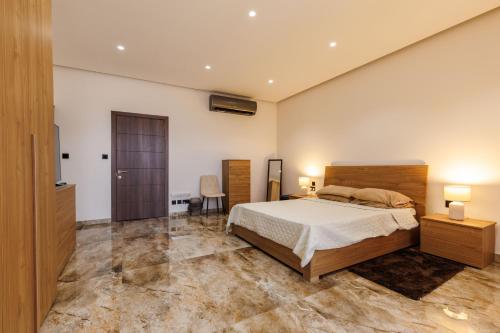 a bedroom with a bed and two lamps and a television at Bayleaf Coastal Apartment in Marsaxlokk