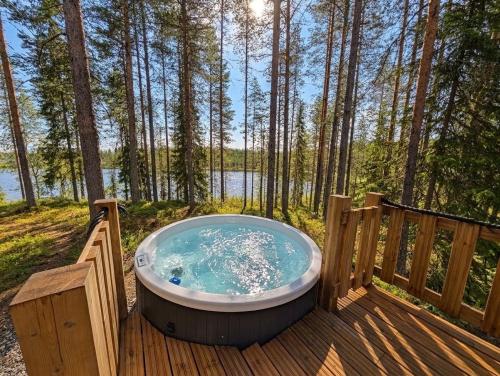a hot tub on a deck in the woods at Villa Kutula in Hossa