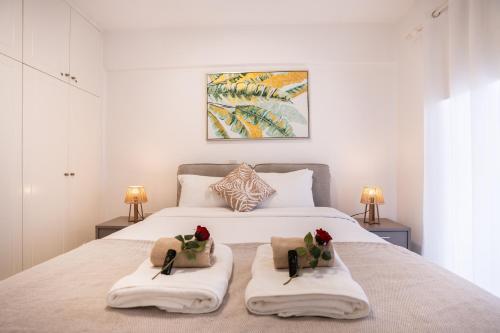 a bedroom with a large bed with two towels at Cozy Apartment in Paphos Beautiful Complex in Paphos