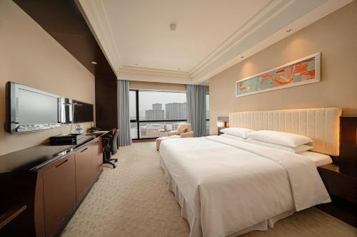 a hotel room with a bed and a flat screen tv at Four Points by Sheraton Hangzhou, Binjiang in Hangzhou