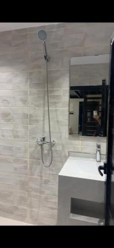 a bathroom with a shower with a sink and a mirror at منتجع النادر الريفي in Az Zulfi