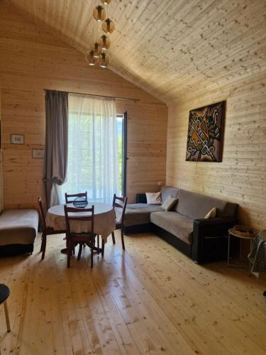 a living room with a couch and a table at Cottage in Tskhvarichamia forest 2 in Tsʼkhvarichamia