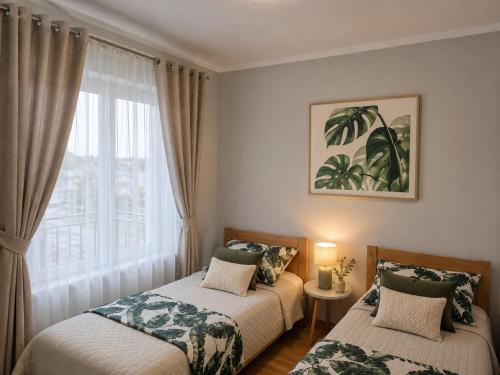 a bedroom with two beds and a window at Apartament Fabryczna TK in Namysłów