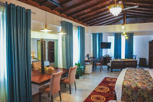 ein Hotelzimmer mit Bett und Esszimmer in der Unterkunft Thilanka Hotel in Kandy