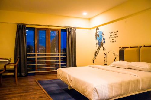 a bedroom with a bed and a poster of a woman on the wall at Villa Park in Mysore