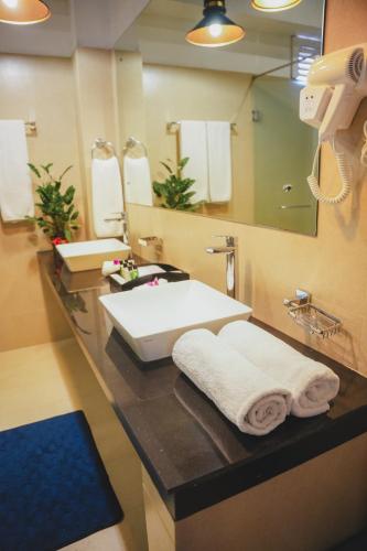 ein Badezimmer mit Waschbecken und großem Spiegel in der Unterkunft Thilanka Hotel in Kandy