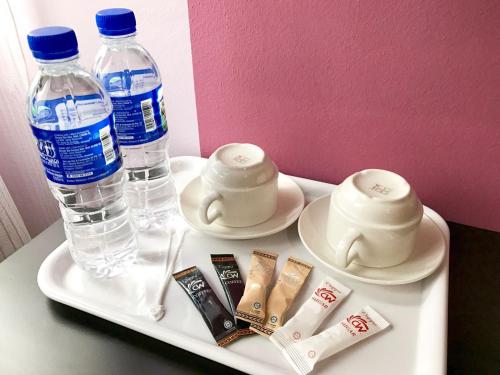 a tray with two bottles of water and two cups at Elmark Hotel Kuantan in Kuantan