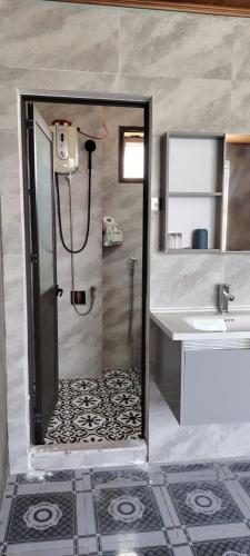 a bathroom with a shower with a door and a sink at VNJ Capsule 216 in Hoi An