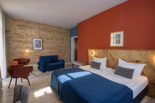 a hotel room with a bed and a blue chair at Boutique Hotel Schwarzer Baer in Lutherstadt Wittenberg