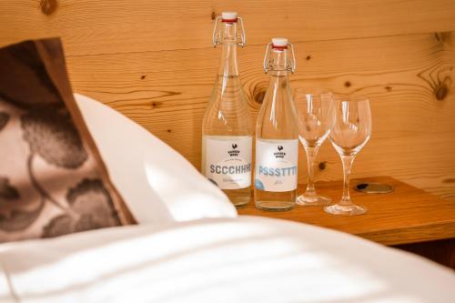 two bottles of wine sitting on a table with wine glasses at Berghotel Hahnenmoos in Adelboden