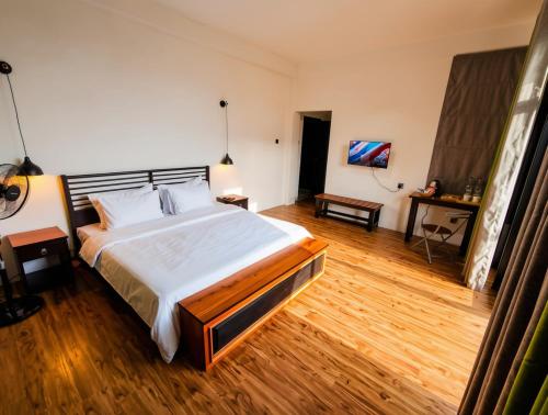 a bedroom with a large bed and a wooden floor at Ella Claython Hills in Ella