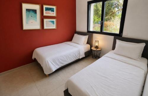 two beds in a room with red walls at VILLA LE CORAIL ROUGE CORSE in Lecci