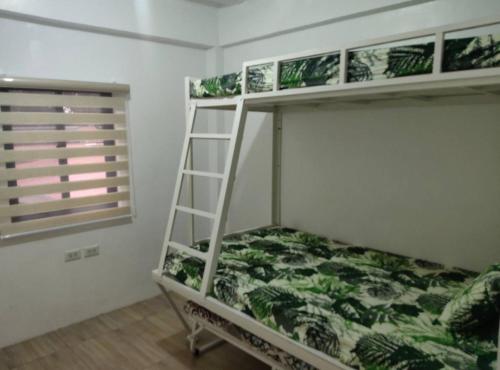 a bunk bed in a room with a ladder at DVM Transient Inn by RedDoorz in Santo Tomas