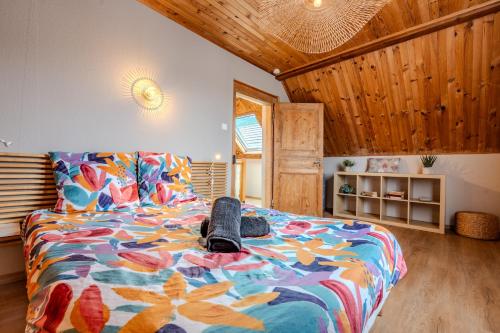 a bedroom with a bed with a colorful comforter at RIESLING - Vue imprenable sur le vignoble - rénové récemment - parking gratuit in Riquewihr