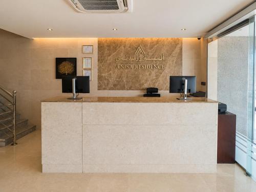 an office with a reception desk with two monitors on it at Anisa Residence in Salalah