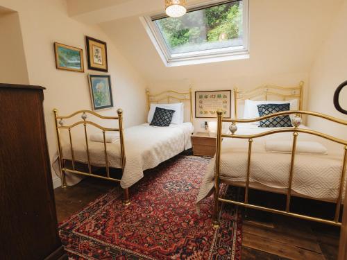 a bedroom with two beds and a window at Cwmalis Hall in Llangollen