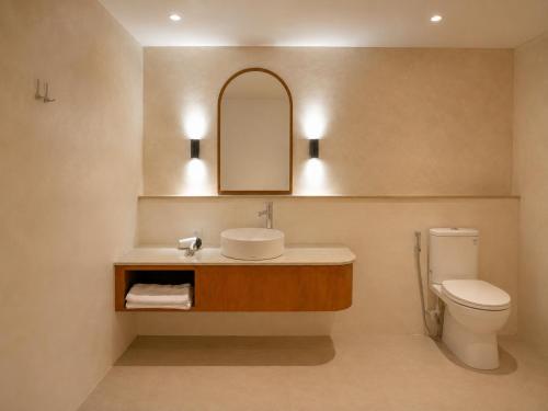 a bathroom with a sink and a toilet at Hu'u Beach Front Hotel in Gili Trawangan