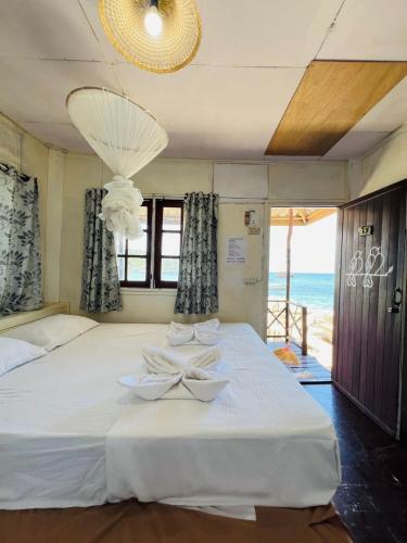 a bedroom with a bed with a view of the ocean at OK Bungalow in Ko Tao