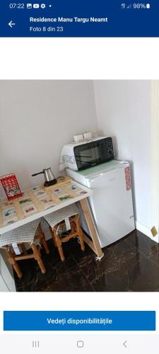 a microwave sitting on top of a table next to a refrigerator at Residence Manu Tg Neamț in Târgu Neamț