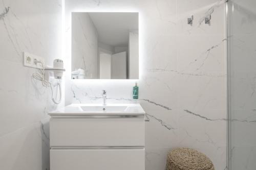 a white bathroom with a sink and a mirror at Martin De Aldehuela Apartment in Ronda