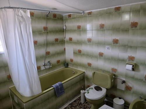 a bathroom with a tub and a toilet and a sink at Chrysafenia's House in Mandrákion