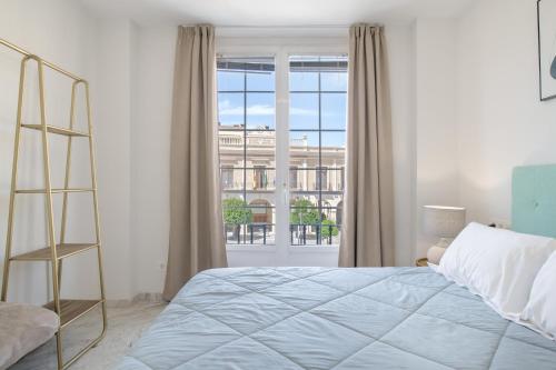 a bedroom with a bed and a large window at Martin De Aldehuela Apartment in Ronda