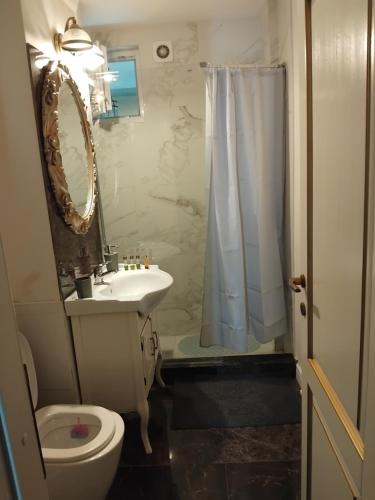 a bathroom with a sink and a toilet and a mirror at Residence Manu Tg Neamț in Târgu Neamț
