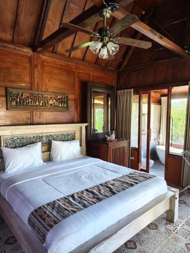 a bedroom with a large bed with a ceiling at Aramaya Hills Boutique in Banjar