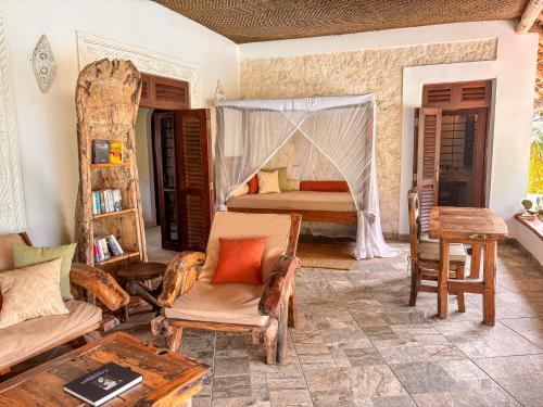 a bedroom with a bed and a table and chairs at Villa Juliana in Jambiani