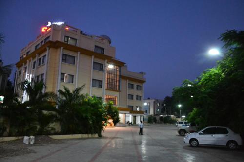 a building at night with cars parked in front of it at Hotel City Heart Shirdi in Shirdi
