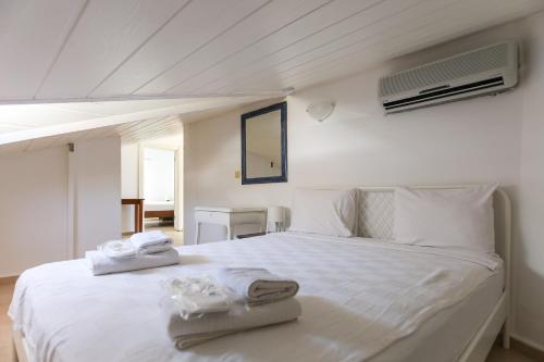 a bedroom with a white bed with towels on it at Kale Aparts in Kaş