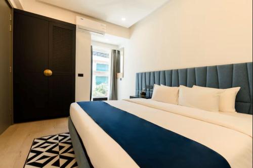 a bedroom with a blue and white bed and a window at Calangute Heights in Calangute