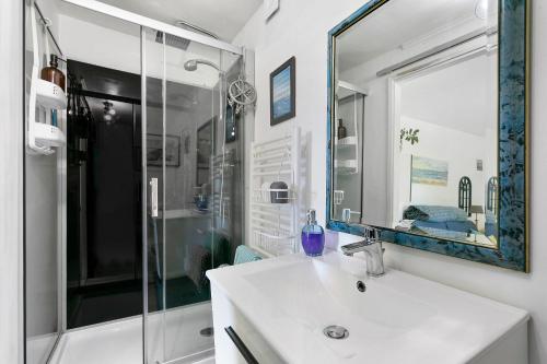 a bathroom with a sink and a shower and a mirror at Le Petit Bécot De Paimpol in Paimpol