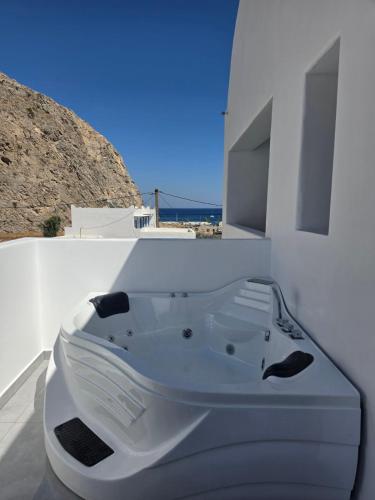 a white bath tub sitting on the side of a building at Angelo Boutique Hotel Santorini in Perissa