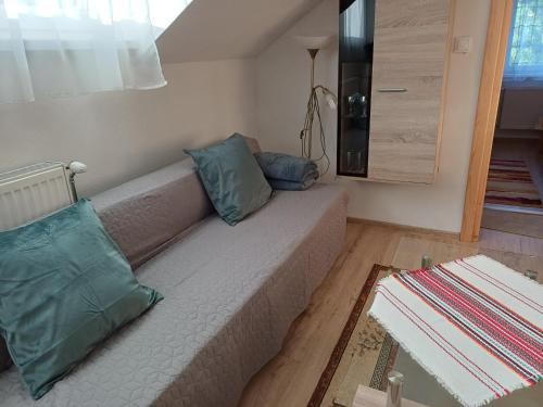 a living room with a couch with two pillows at Ubytovanie Málika in Čierny Blh