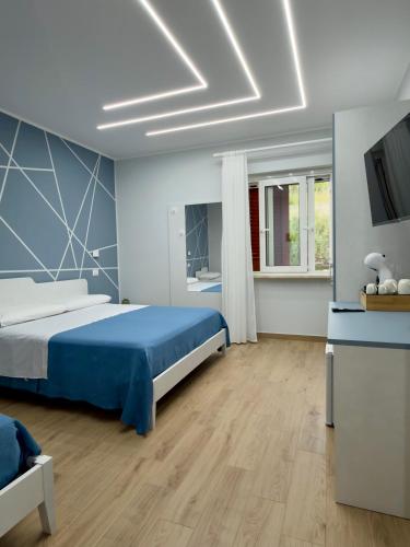 a bedroom with a blue bed and a television at Tra 2 Blu Guest House in Belvedere Marittimo